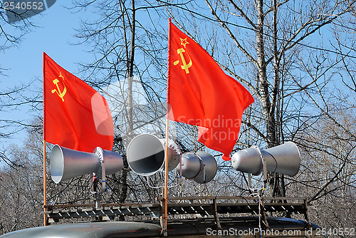 Image of red flags and megaphones on the roof of a car