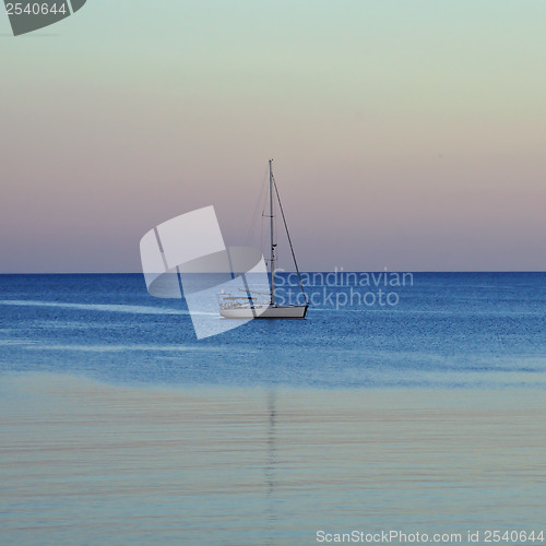 Image of sailboat reflected on sea water