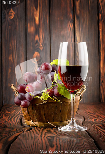Image of Wine glass and grapes in a basket