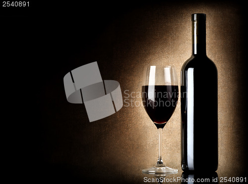 Image of Wine bottle and wineglass on a old background