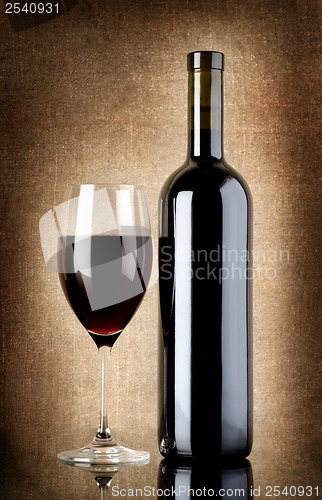 Image of Wine bottle and wineglass on a old canvas