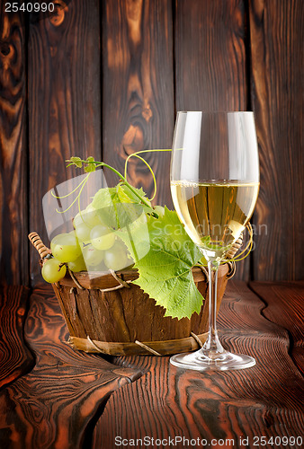 Image of Glass of white wine and grapes
