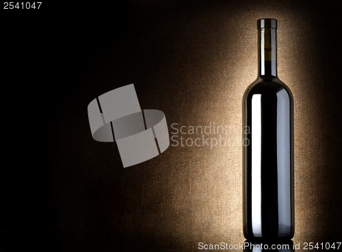 Image of Red wine bottle on a old canvas