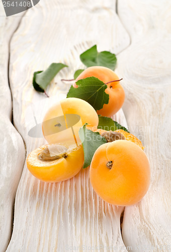 Image of Apricots and leaves on a table