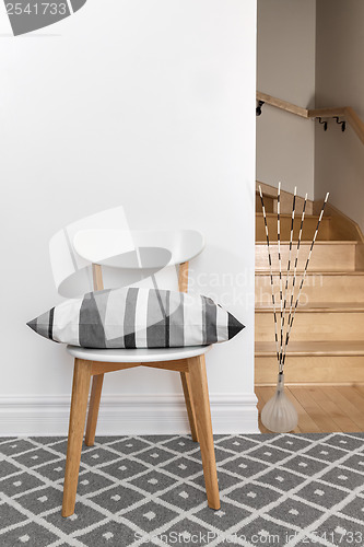 Image of Chair with cushion in a room with staircase