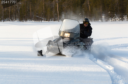 Image of man riding a snowmobile