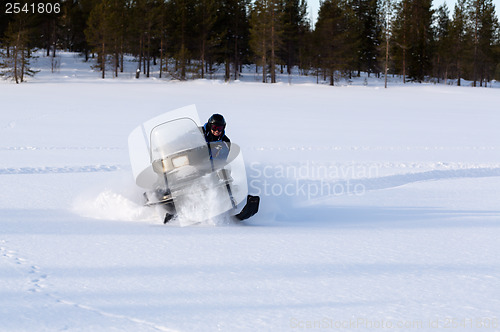 Image of man riding a snowmobile