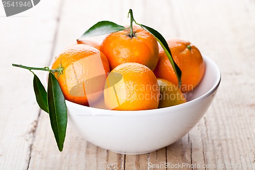 Image of tangerines with leaves in bowl