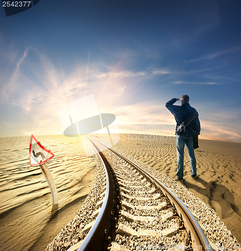 Image of Man and railway in desert