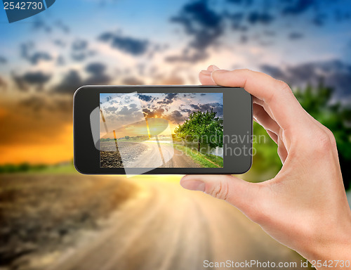 Image of Phone and evening landscape