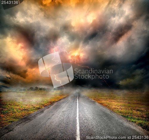 Image of Storm clouds and lightning over highway