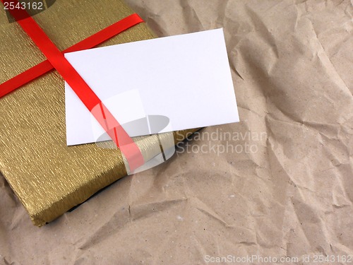 Image of golden gift box with red bow on vintage old paper