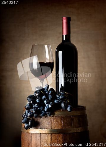 Image of Red wine with barrel and grapes