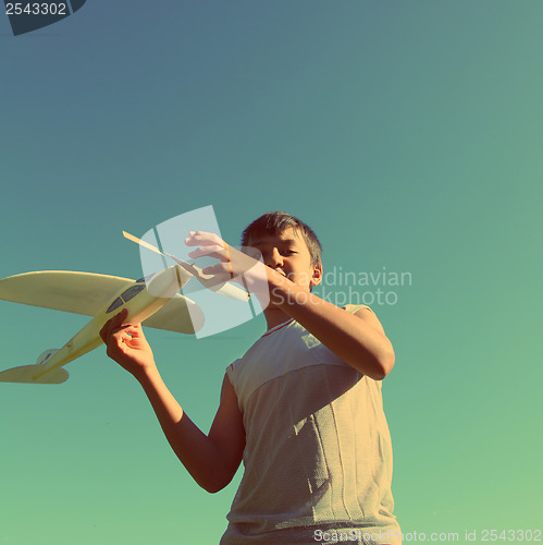 Image of asian boy running airplane model - vintage retro style
