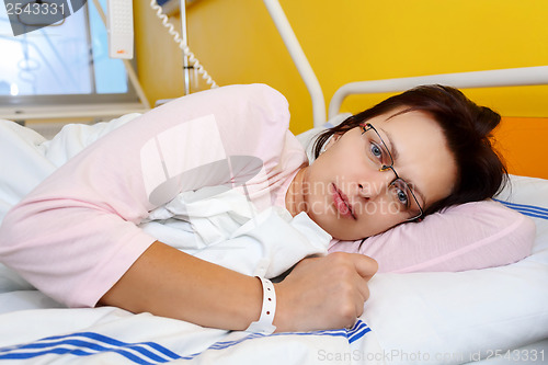 Image of sad middle-aged woman lying in hospital