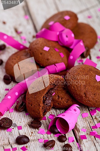 Image of fresh chocolate cookies, coffee beans, pink ribbons and confetti