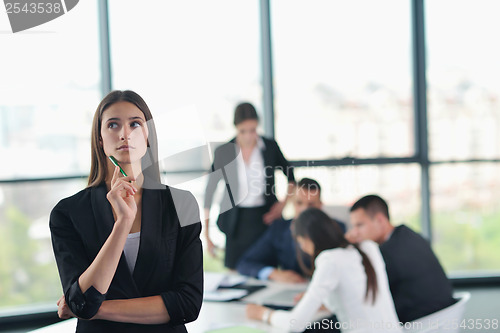 Image of business woman with her staff in background at office