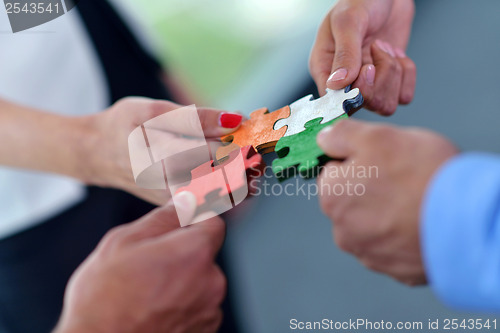 Image of Group of business people assembling jigsaw puzzle