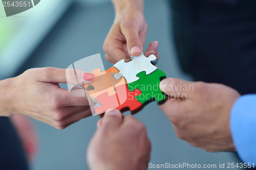 Image of Group of business people assembling jigsaw puzzle