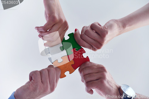 Image of Group of business people assembling jigsaw puzzle