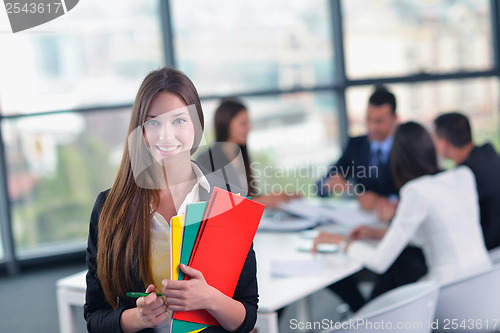 Image of business woman with her staff in background at office