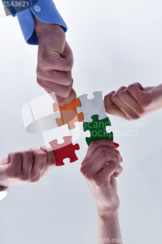 Image of Group of business people assembling jigsaw puzzle