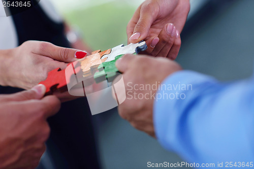 Image of Group of business people assembling jigsaw puzzle