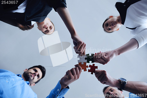 Image of Group of business people assembling jigsaw puzzle