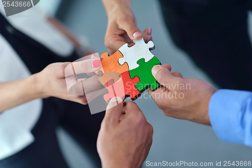 Image of Group of business people assembling jigsaw puzzle