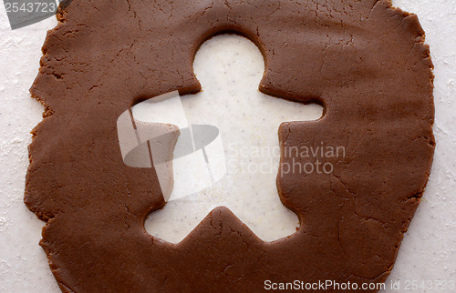 Image of Cutout shape of a gingerbread man in cookie dough