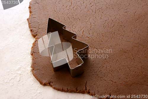 Image of Cutting out a Christmas tree from gingerbread