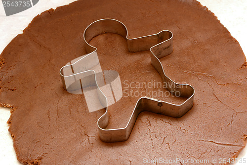 Image of Gingerbread man cutter on cookie dough