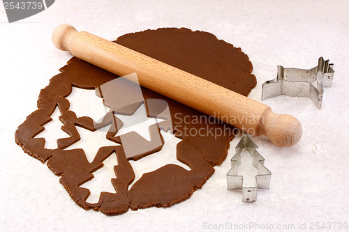 Image of Rolling pin and festive cookie cutters with gingerbread dough