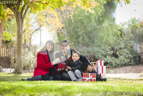 Image of Mixed Race Family Enjoying Christmas Gifts in the Park Together