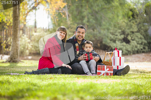 Image of Mixed Race Family Enjoying Christmas Gifts in the Park Together