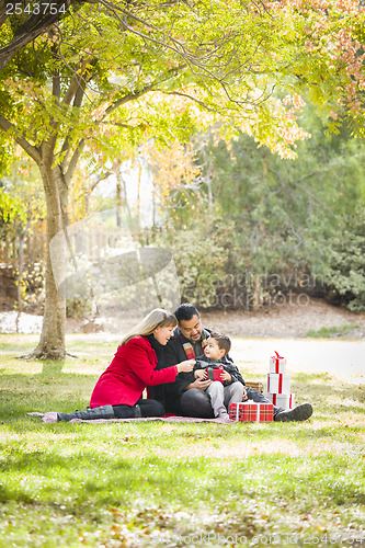 Image of Mixed Race Family Enjoying Christmas Gifts in the Park Together