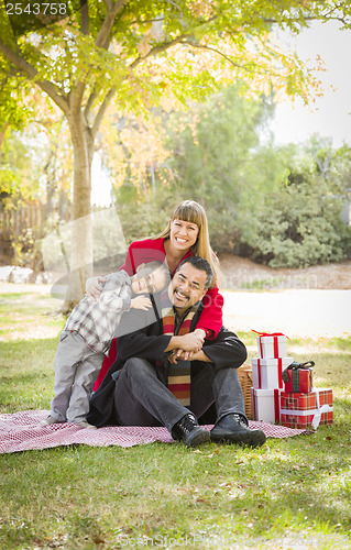 Image of Mixed Race Family Enjoying Christmas Gifts in the Park Together