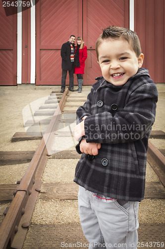 Image of Mixed Race Boy at Train Depot with Parents Smiling Behind