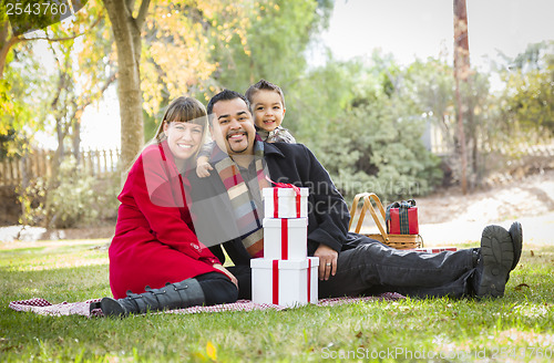 Image of Mixed Race Family Enjoying Christmas Gifts in the Park Together