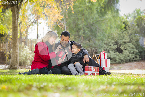 Image of Mixed Race Family Enjoying Christmas Gifts in the Park Together