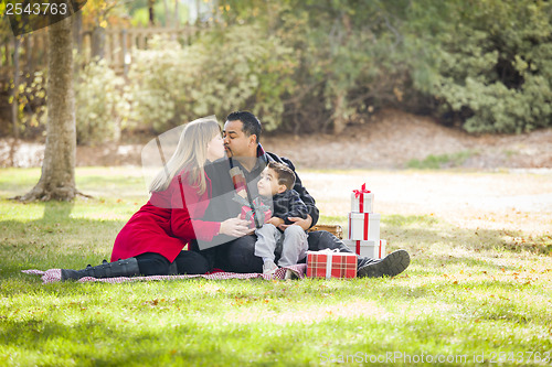 Image of Mixed Race Family Enjoying Christmas Gifts in the Park Together