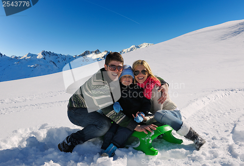 Image of family having fun on fresh snow at winter vacation