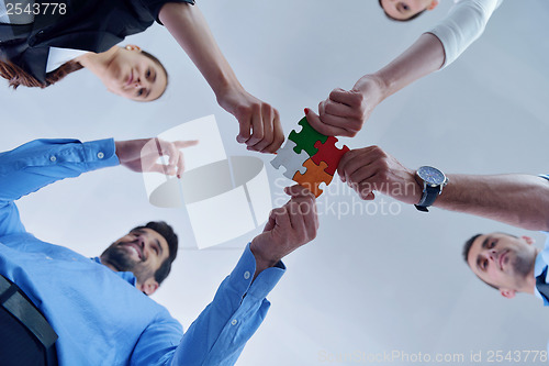 Image of Group of business people assembling jigsaw puzzle