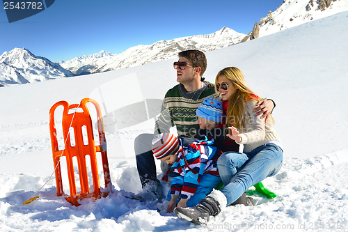 Image of family having fun on fresh snow at winter vacation