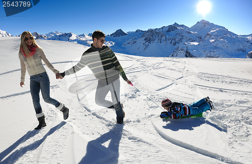 Image of family having fun on fresh snow at winter vacation