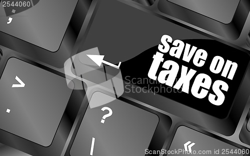 Image of save on taxes word on laptop keyboard key, business concept