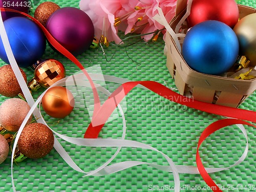 Image of beautiful flowers, gifts and Christmas balls on green background