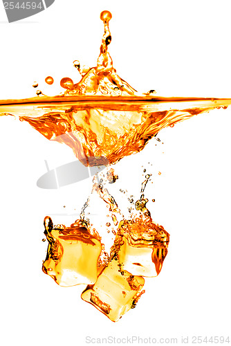 Image of ice cubes dropped into orange water with splash isolated on whit