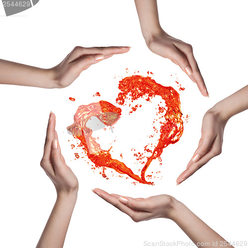 Image of Red heart from water splash with human hands isolated on white