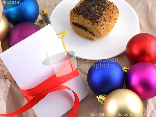 Image of cake with christmas balls and white invitation card